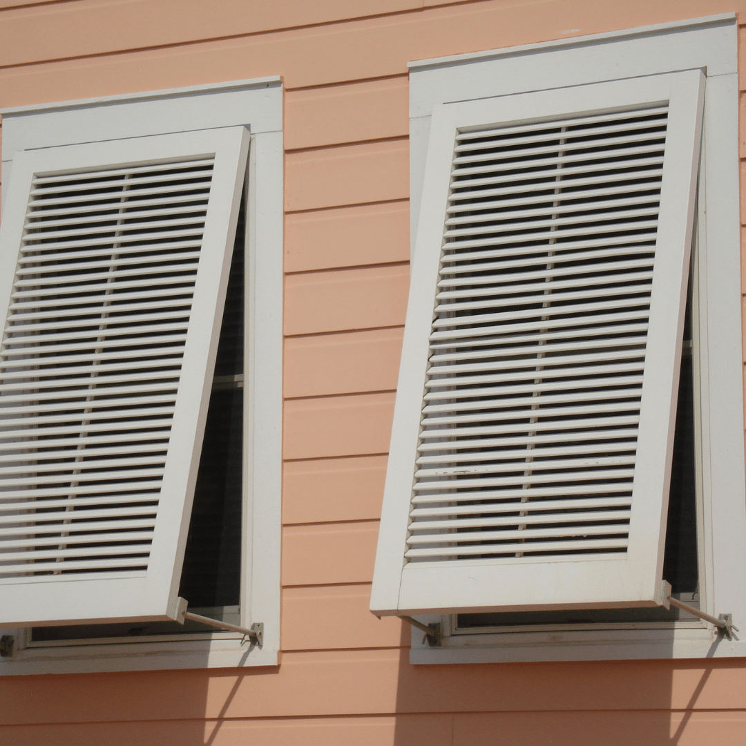two windows with white shutters on a pink building.